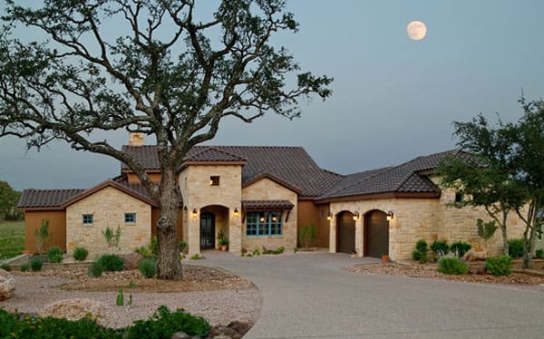 Stone house with oak tree under moonlight